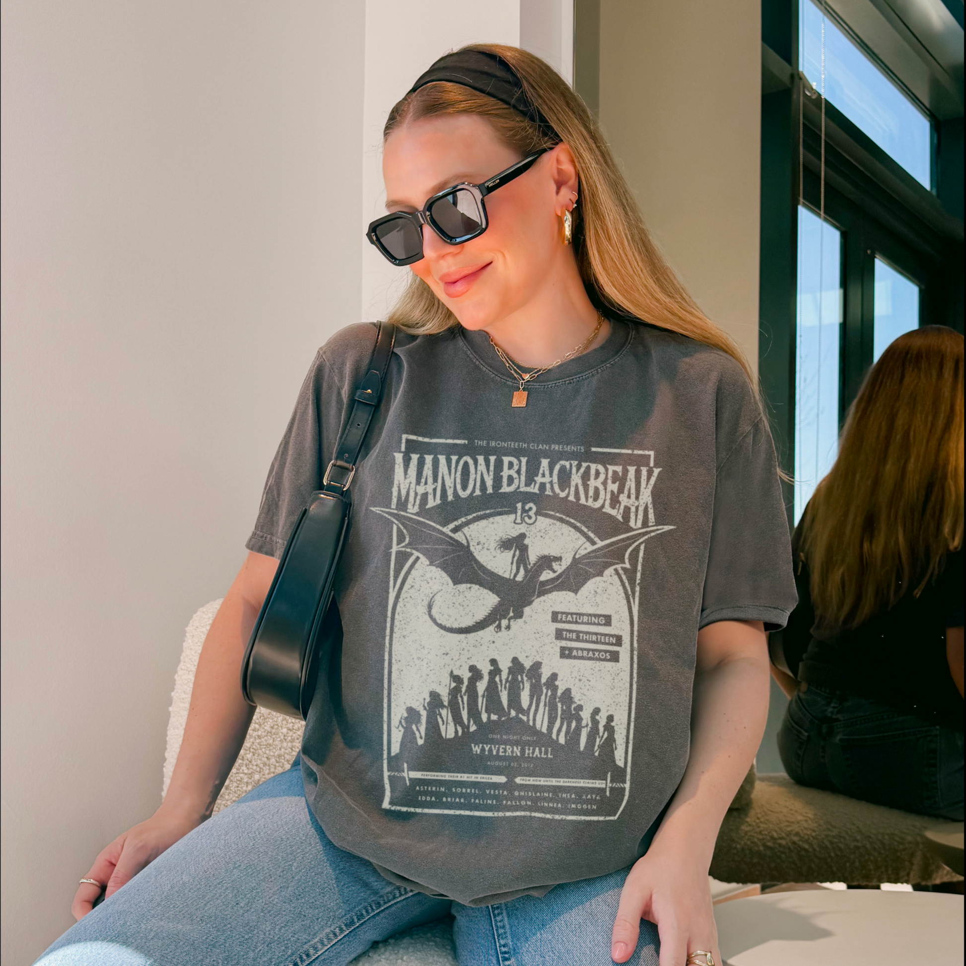 Woman wearing Manon Blackbeak and the Thirteen shirt – Throne of Glass merch styled with casual outfit and sunglasses